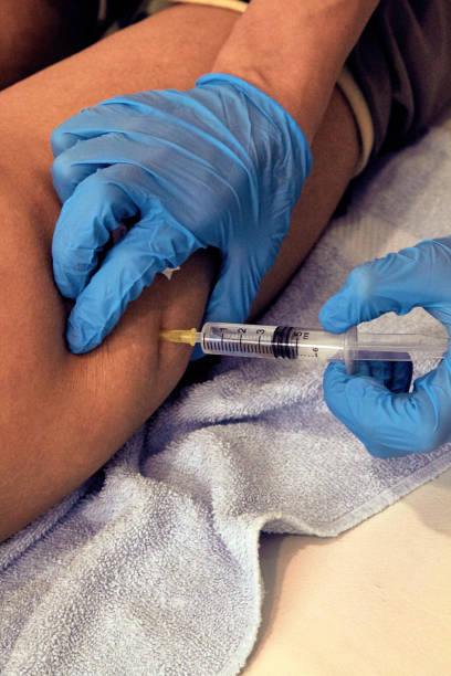 istock Woman lying on bed and getting botox injection. 1199648110