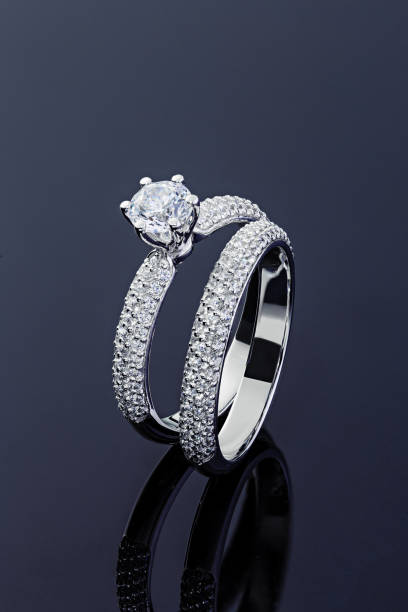 istock Female engagement and wedding rings with diamonds on black background 1199648366