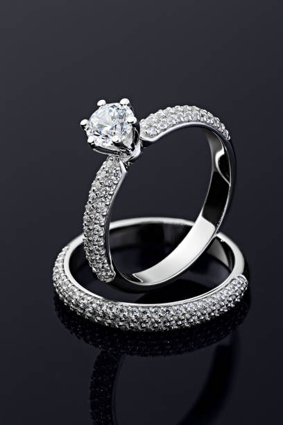 istock Female engagement and wedding rings with diamonds on black background 1199648411