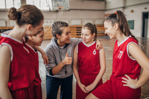 istock Coach standing with basketball team 1199648773