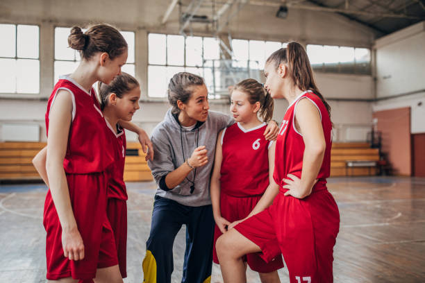 istock Coach standing with basketball team 1199649064
