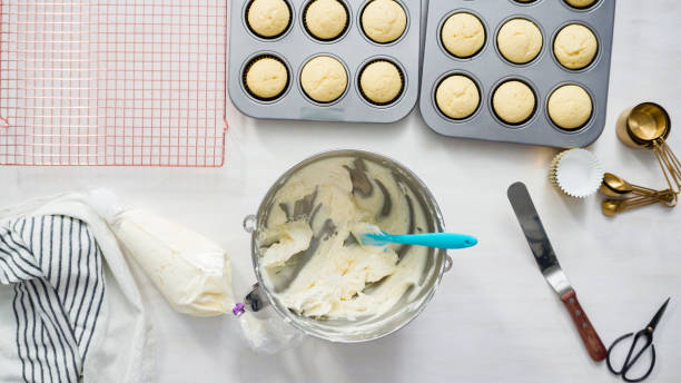 recoger un crema de mantequilla blanca glaseado en una bolsa de tuberías - mixing bowl fotografías e imágenes de stock