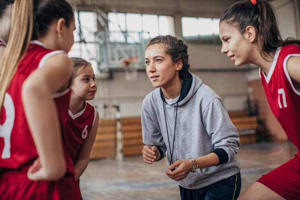 istock Coach standing with basketball team 1199649297