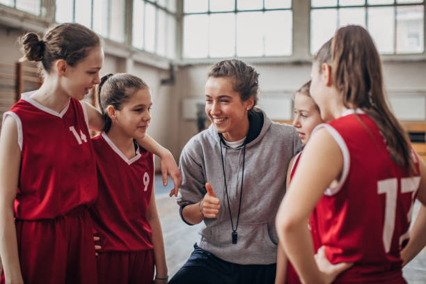 istock Coach standing with basketball team 1199649450