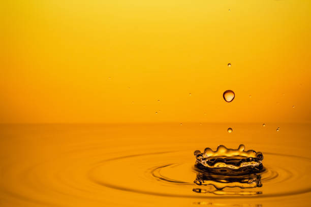 istock Golden Oil Drops on Yellow Background. 1199651080