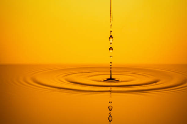 istock Golden Oil Drops on Yellow Background. 1199651088