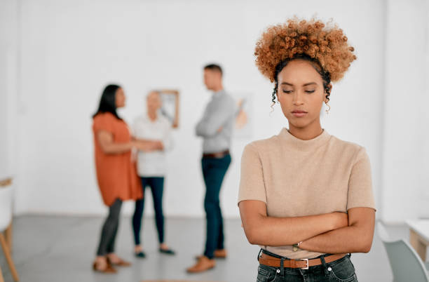 Nothing good can come from bullying Shot of a young businesswoman being excluded from her colleagues in a modern office brat stock pictures, royalty-free photos & images