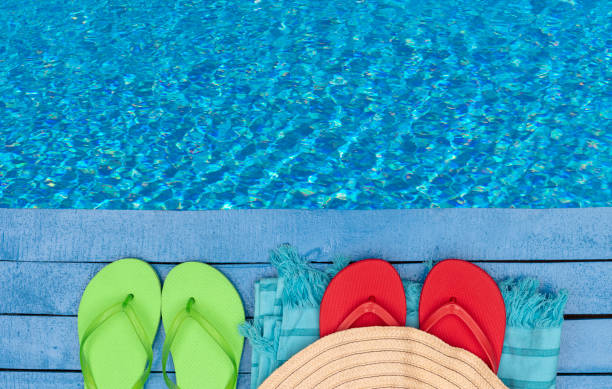 flipflops, strandtuch und hut am pool - green shoe blue in a row stock-fotos und bilder