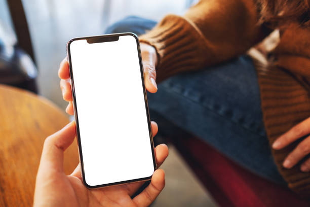 une femme tenant et affichant le téléphone portable blanc avec l'écran noir blanc de bureau à quelqu'un - showcase exterior photos et images de collection