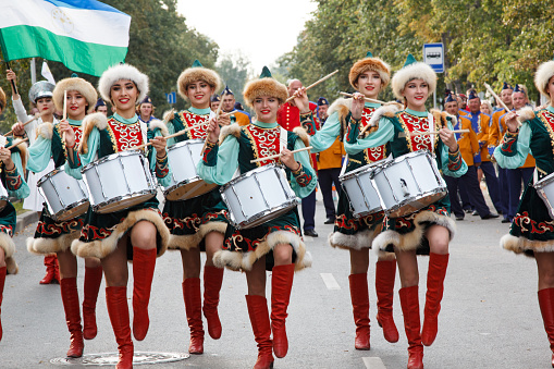 Ekaterinburg, Russia - August, 18, 2019. City Day Celebration. Festival of marching drum bands. Musicians Buryatia women dressed ethnic clothes. Masquerade procession of drummers marching down street