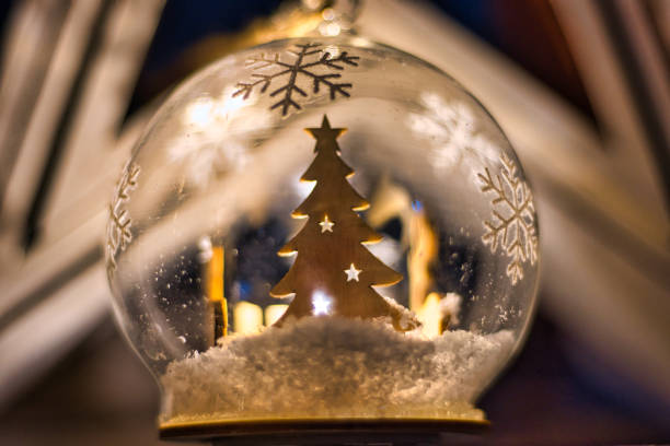 Mirabel-aux-Baronnies, France - December 30, 2019 - Close-up view of an artisanal Christmas ball containing a small wooden tree and fake snow and a light.