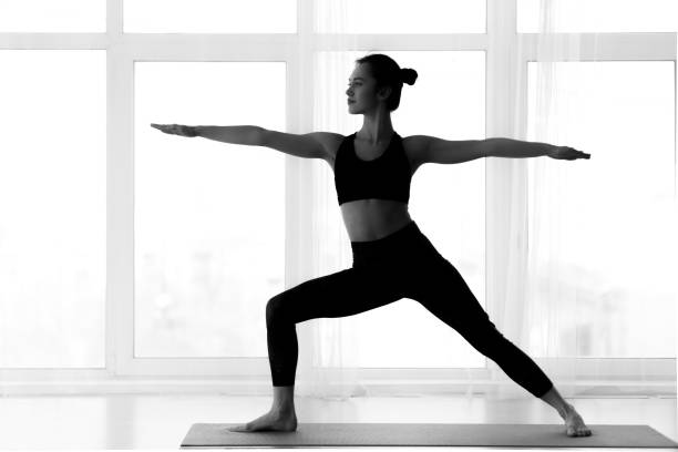 istock Silhouette of woman making warrior yoga pose 1199660927