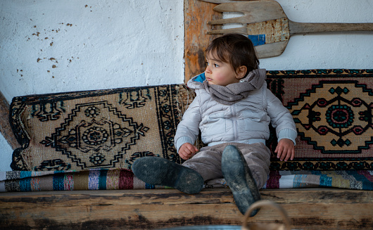 Boy sitting on old couch in the farmhouse