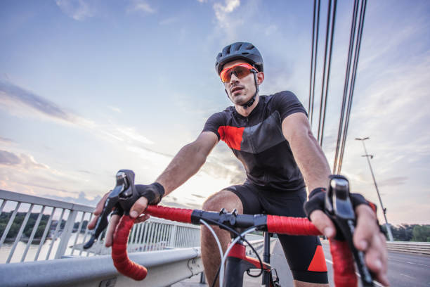 atleta montando en bicicleta en la carretera - speed sports race track cycling vitality fotografías e imágenes de stock