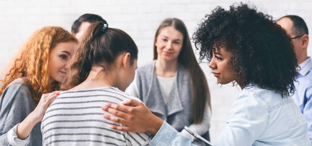 istock Support group patients comforting woman at therapy session 1199664822