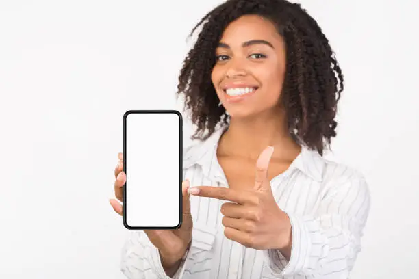 Photo of Happy black girl showing white mobile screen