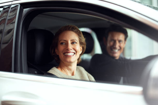 Traveling by car Handsome adult couple is traveling by a car. They are looking through the window and smiling. georgijevic frankfurt stock pictures, royalty-free photos & images