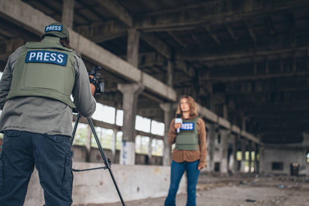 istock Man and woman journalists reporting from the war zone 1199665970