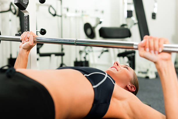 istock Woman in gym exercising with barbell 119966599