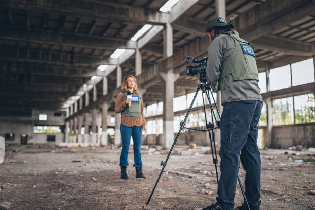 istock Man and woman journalists reporting from the war zone 1199666000