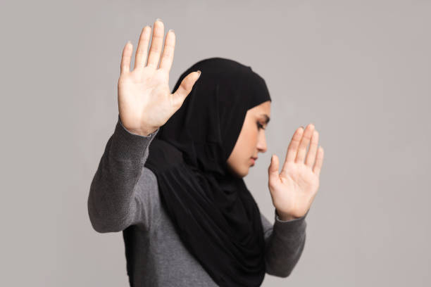 istock Afraid arabic girl showing stop gesture, protecting herself from violence 1199666338