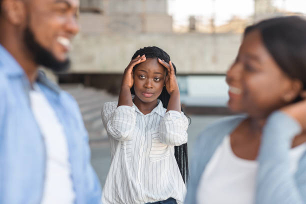 Upset black woman watching her boyfriend flirting with other girl outdoors Upset afro girl seeing her boyfriend flirting with other girl outdoors, standing in despair on background former photos stock pictures, royalty-free photos & images