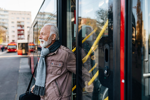 Mature Businessman get out a City Bus on a Cold Winter Day