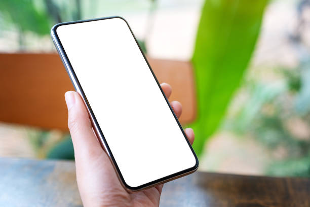 istock hands holding black mobile phone with blank desktop screen with green nature background 1199666880