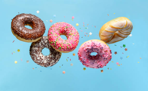 istock Flying donuts. Mix of multicolored doughnuts with sprinkel on blue background. 1199667089