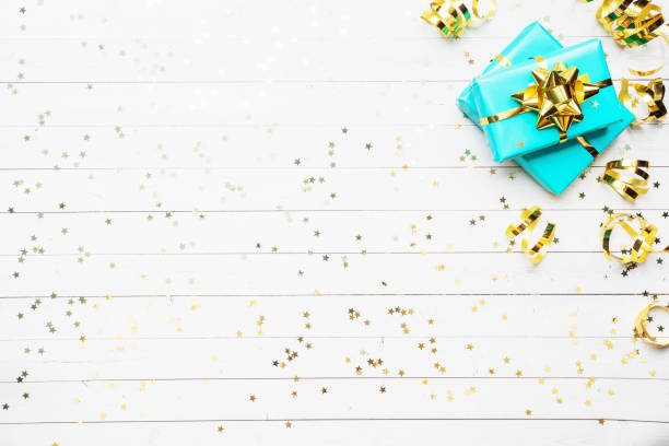 istock Gift boxes with gold ribbons and bows, confetti stars on a white background. Copy space Flat lay. Greeting card for birthday party, Christmas Wedding mother's Day. 1199667171