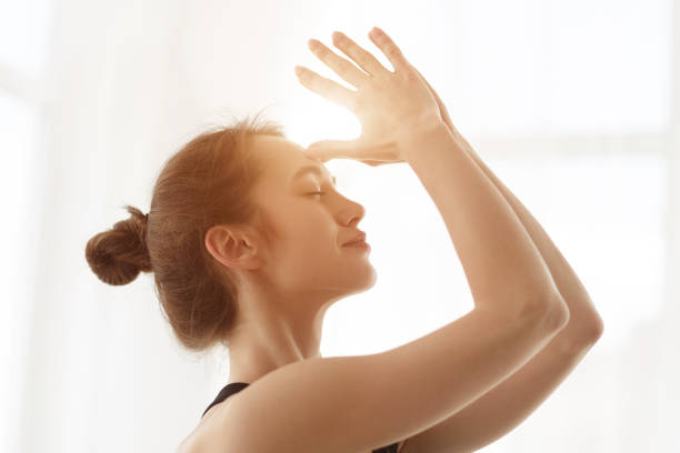 istock Keep calm. Woman meditating, holding hands together on forehead 1199667958