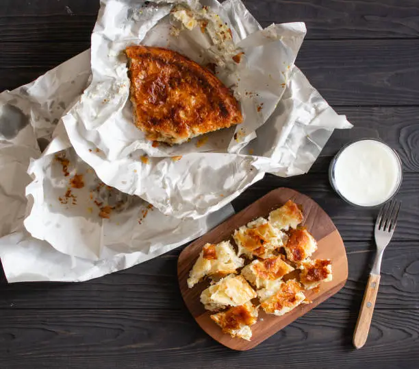 Photo of Burek or Borek savory pastry pie from the balkans served with yogurt top view.