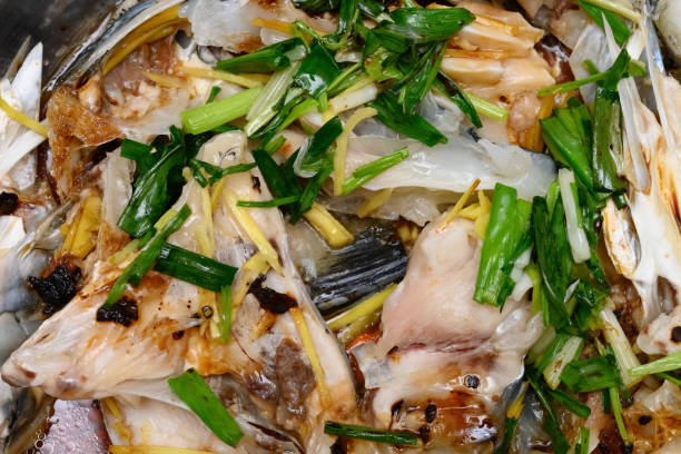 istock fresh steamed fish covered with herbs onions and sauce 1199669925