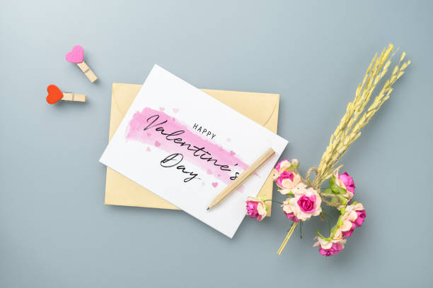 istock Mockup blank postcard and envelope on grey table background with craft rose flower. Mock up for elegant design. Flat lay top view with copy space for valentine`s day background concept. 1199670529