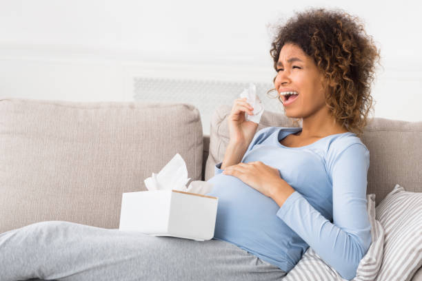 istock Depression and pregnancy. Expectant woman crying, sitting on sofa 1199672064