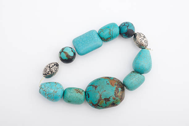 Closeup of a bracelet made with turquoise and silver beads.