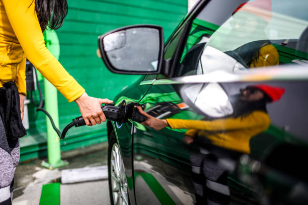 plugging a charging connector into an electric vehicle - power supply power supply box power equipment imagens e fotografias de stock