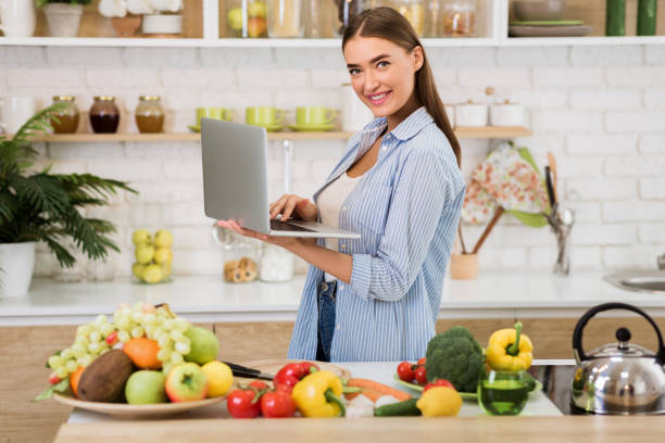 istock Recipe search. Young woman using laptop in the kitchen 1199675119