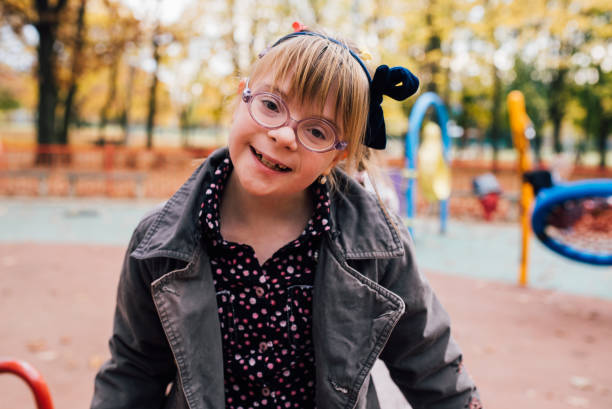 verticale d'une fille mignonne avec le syndrome de down - child little girls smiling autumn photos et images de collection