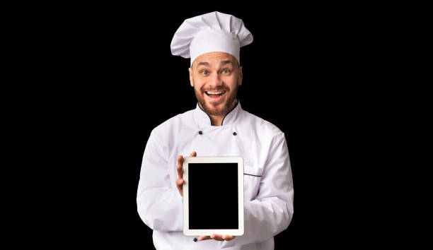 istock Chef Man Showing Tablet Blank Screen Standing On Black Background 1199676944