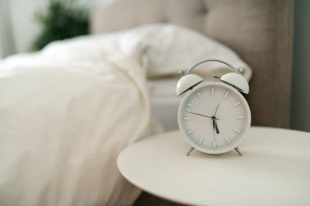 istock white alarm clock and bed at home 1199676946