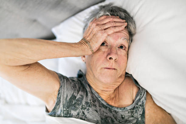 istock Senior aged woman on bed at home feeling sad 1199677121