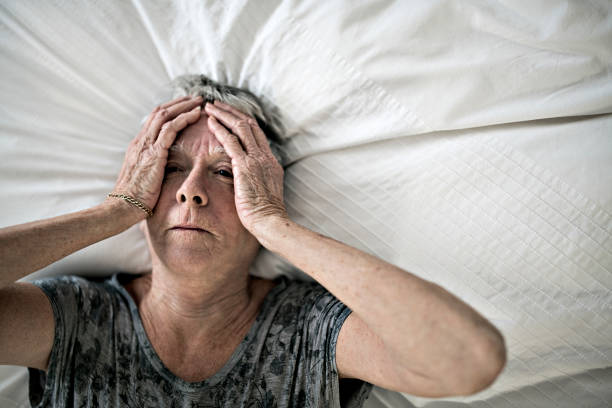 istock Senior aged woman on bed at home feeling sad 1199677215