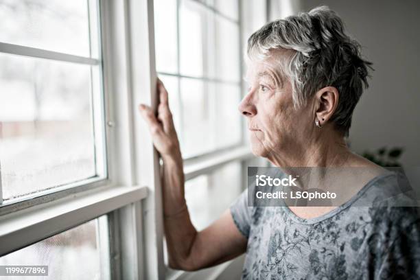 A Sad Lonely 70 Years Old Senior In Is Apartment Stock Photo - Download Image Now - Senior Adult, Loneliness, Senior Women