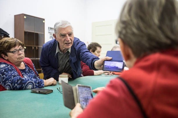 istock Senior Adults Using Mobile Phones at Social Gathering 1199678071