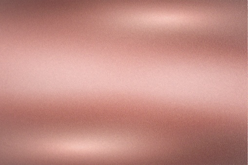 Pared metálica de oro rosa cepillado con superficie rayada, fondo de textura abstracta photo