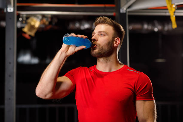 istock Young handsome man drinking energy drinks at the gym 1199678216