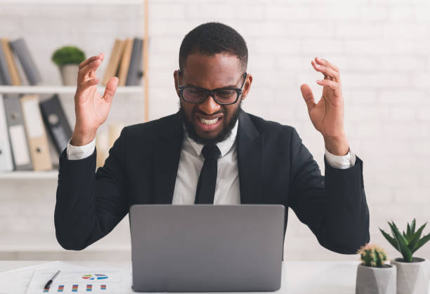 istock Indignant businessman reading emails on laptop in modern office 1199679637