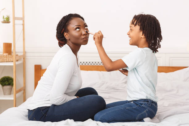 istock Happy african child doing makeup for mommy 1199679744
