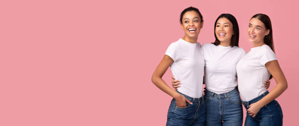 trois femmes heureuses posant sur le fond rose de studio, panorama - t shirt shirt pink blank photos et images de collection